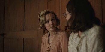 Movie still from “The Dig” (2021), directed by Simon Stone – A woman wearing a hat looking at a woman; Close Up shot, Over the shoulder angle