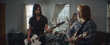 Movie still from “The Dirt” (2019), directed by Jeff Tremaine – A group of people that are in a room with guitars; Medium shot, Low angle