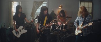 Movie still from “The Dirt” (2019), directed by Jeff Tremaine – A group of people that are in a room; Medium shot, Low angle