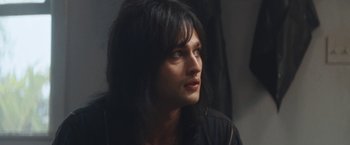 Movie still from “The Dirt” (2019), directed by Jeff Tremaine – A woman with long hair looking to her left; Close Up shot, Over the shoulder angle