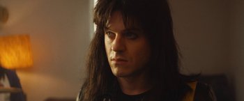 Movie still from “The Dirt” (2019), directed by Jeff Tremaine – A person with long black hair; Close Up shot, Low angle