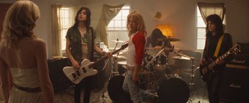 Movie still from “The Dirt” (2019), directed by Jeff Tremaine – A group of people that are in a room with instruments; Wide shot, Low angle