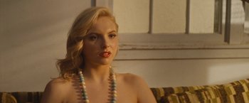 Movie still from “The Dirt” (2019), directed by Jeff Tremaine – A woman sitting on a couch wearing a necklace; Close Up shot, Over the shoulder angle
