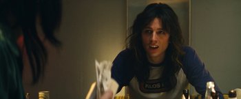 Movie still from “The Dirt” (2019), directed by Jeff Tremaine – A person with long black hair is holding a piece of paper; Close Up shot, Low angle