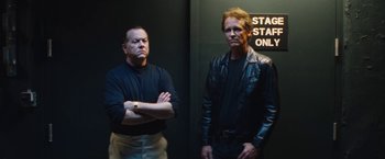 Movie still from “The Dirt” (2019), directed by Jeff Tremaine – A couple of men standing next to each other in a room; Medium shot, Low angle