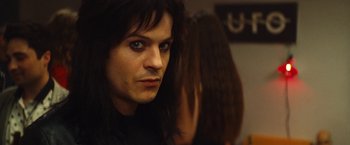 Movie still from “The Dirt” (2019), directed by Jeff Tremaine – A person with long black hair; Close Up shot, Over the shoulder angle