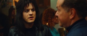 Movie still from “The Dirt” (2019), directed by Jeff Tremaine – A man with long black hair is talking to another man; Close Up shot, Over the shoulder angle