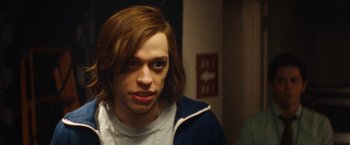 Movie still from “The Dirt” (2019), directed by Jeff Tremaine – A man with long brown hair is looking at the camera; Close Up shot, Over the shoulder angle