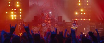 Movie still from “The Dirt” (2019), directed by Jeff Tremaine – A person on a stage playing a guitar; Wide shot, High angle