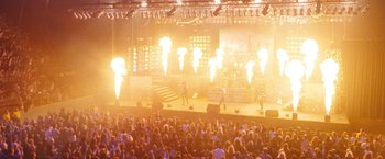 Movie still from “The Dirt” (2019), directed by Jeff Tremaine – A large crowd of people watching a band perform on a stage; Extreme Wide shot, High angle