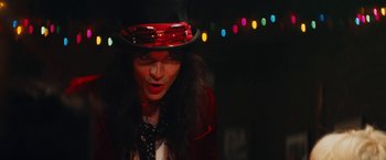 Movie still from “The Dirt” (2019), directed by Jeff Tremaine – A man in a red jacket and a black hat; Medium shot, Low angle