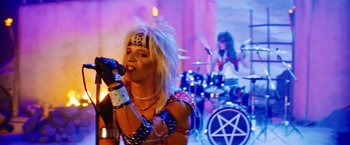 Movie still from “The Dirt” (2019), directed by Jeff Tremaine – A man in a rock band drinking a drink; Medium shot, High angle