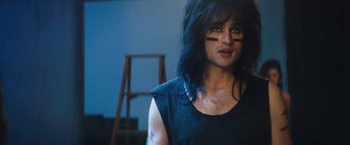Movie still from “The Dirt” (2019), directed by Jeff Tremaine – A person with a black shirt and long black hair; Close Up shot, Over the shoulder angle