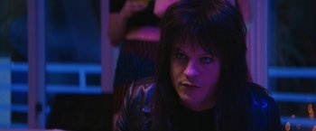 Movie still from “The Dirt” (2019), directed by Jeff Tremaine – A person with long hair and a black jacket; Close Up shot, Over the shoulder angle