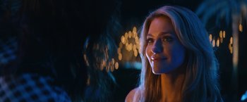 Movie still from “The Dirt” (2019), directed by Jeff Tremaine – A beautiful young lady standing in front of a bunch of lights at night; Close Up shot, Over the shoulder angle
