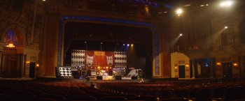 Movie still from “The Dirt” (2019), directed by Jeff Tremaine – A stage with lights and people in the seats; Extreme Wide shot, High angle