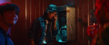 Movie still from “The Dirt” (2019), directed by Jeff Tremaine – A man talking on a phone next to an old payphone; Medium shot, High angle