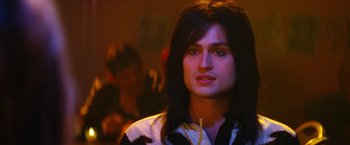 Movie still from “The Dirt” (2019), directed by Jeff Tremaine – A man with long black hair is looking at the camera; Close Up shot, Low angle