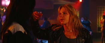 Movie still from “The Dirt” (2019), directed by Jeff Tremaine – A woman holding a glass of wine in her right hand; Close Up shot, Low angle