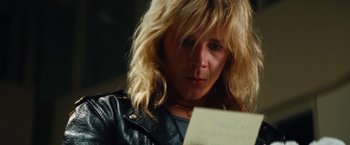 Movie still from “The Dirt” (2019), directed by Jeff Tremaine – A woman looking down at a piece of paper; Close Up shot, Over the shoulder angle