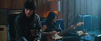 Movie still from “The Dirt” (2019), directed by Jeff Tremaine – A couple of people that are playing some instruments; Medium shot, Low angle