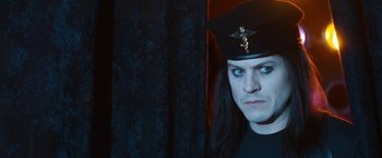 Movie still from “The Dirt” (2019), directed by Jeff Tremaine – A man with long black hair wearing a black hat; Close Up shot, Low angle