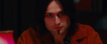 Movie still from “The Dirt” (2019), directed by Jeff Tremaine – A person with long black hair; Close Up shot, Low angle