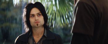 Movie still from “The Dirt” (2019), directed by Jeff Tremaine – A person with long black hair; Close Up shot, Low angle