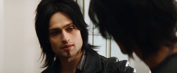 Movie still from “The Dirt” (2019), directed by Jeff Tremaine – A person with long black hair; Close Up shot, Over the shoulder angle