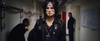 Movie still from “The Dirt” (2019), directed by Jeff Tremaine – A man with black hair and a face paint; Medium shot, Low angle