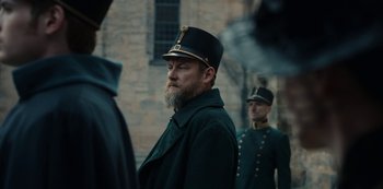 Movie still from “The Empress” (2022), created by Katharina Eyssen – A man with a long beard wearing a hat; Close Up shot, Over the shoulder angle
