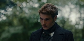 Movie still from “The Empress” (2022), created by Katharina Eyssen – A man in a suit and tie looking to his left; Close Up shot, Over the shoulder angle