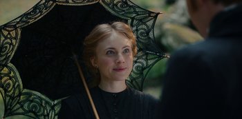 Movie still from “The Empress” (2022), created by Katharina Eyssen – A young woman holding an umbrella in the rain; Close Up shot, Over the shoulder angle