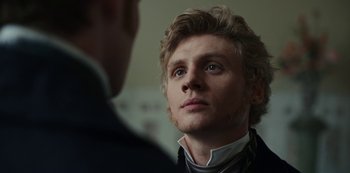 Movie still from “The Empress” (2022), created by Katharina Eyssen – A young man looking into the distance while standing next to another man; Close Up shot, Over the shoulder angle