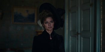 Movie still from “The Empress” (2022), created by Katharina Eyssen – A woman in a black dress and a black hat; Close Up shot, Over the shoulder angle
