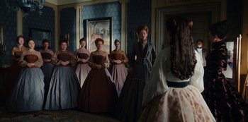 Movie still from “The Empress” (2022), created by Katharina Eyssen – A group of women in period dress standing in front of a painting; Wide shot, Low angle