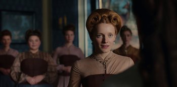 Movie still from “The Empress” (2022), created by Katharina Eyssen – A young woman with a bunch of hair on her head; Close Up shot, Over the shoulder angle