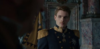 Movie still from “The Empress” (2022), created by Katharina Eyssen – A man in a military uniform standing in front of a flag; Close Up shot, Over the shoulder angle