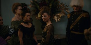Movie still from “The Empress” (2022), created by Katharina Eyssen – A woman in a black dress standing next to another woman in a black dress; Medium shot, Over the shoulder angle