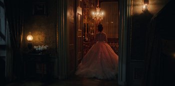 Movie still from “The Empress” (2022), created by Katharina Eyssen – A woman in a white dress standing in front of a mirror; Wide shot, Over the shoulder angle
