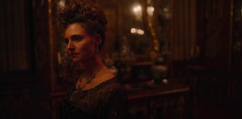 Movie still from “The Empress” (2022), created by Katharina Eyssen – A woman in a black dress with a long necklace; Close Up shot, Over the shoulder angle