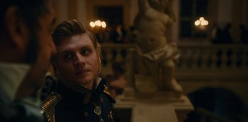 Movie still from “The Empress” (2022), created by Katharina Eyssen – A man in a military uniform standing in front of a statue; Close Up shot, Over the shoulder angle