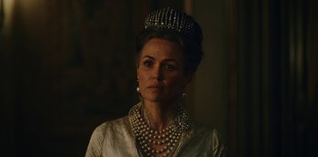 Movie still from “The Empress” (2022), created by Katharina Eyssen – A person wearing a tiara and pearls; Close Up shot, Low angle