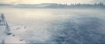 Movie still from “No Time to Die” (2021), directed by Cary Joji Fukunaga – A person standing in the middle of a body of water; Extreme Wide shot, High angle