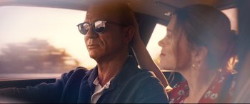 Movie still from “No Time to Die” (2021), directed by Cary Joji Fukunaga – A man and a woman sitting in the back of a car; Close Up shot, Low angle