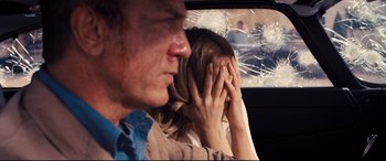 Movie still from “No Time to Die” (2021), directed by Cary Joji Fukunaga – A man and a woman covering their faces in a car; Close Up shot, Over the shoulder angle