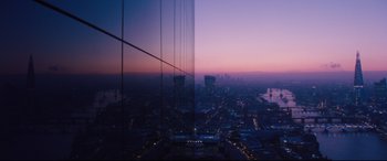 Movie still from “No Time to Die” (2021), directed by Cary Joji Fukunaga – A view of a city at night from a skyscraper; Extreme Wide shot, High angle