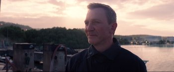 Movie still from “No Time to Die” (2021), directed by Cary Joji Fukunaga – A person wearing a black shirt; Close Up shot, Over the shoulder angle