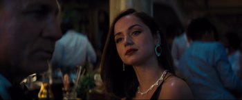 Movie still from “No Time to Die” (2021), directed by Cary Joji Fukunaga – A beautiful woman with long dark brown hair wearing a necklace; Close Up shot, Over the shoulder angle