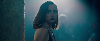 Movie still from “No Time to Die” (2021), directed by Cary Joji Fukunaga – A beautiful woman with dark hair and red lipstick; Close Up shot, Over the shoulder angle